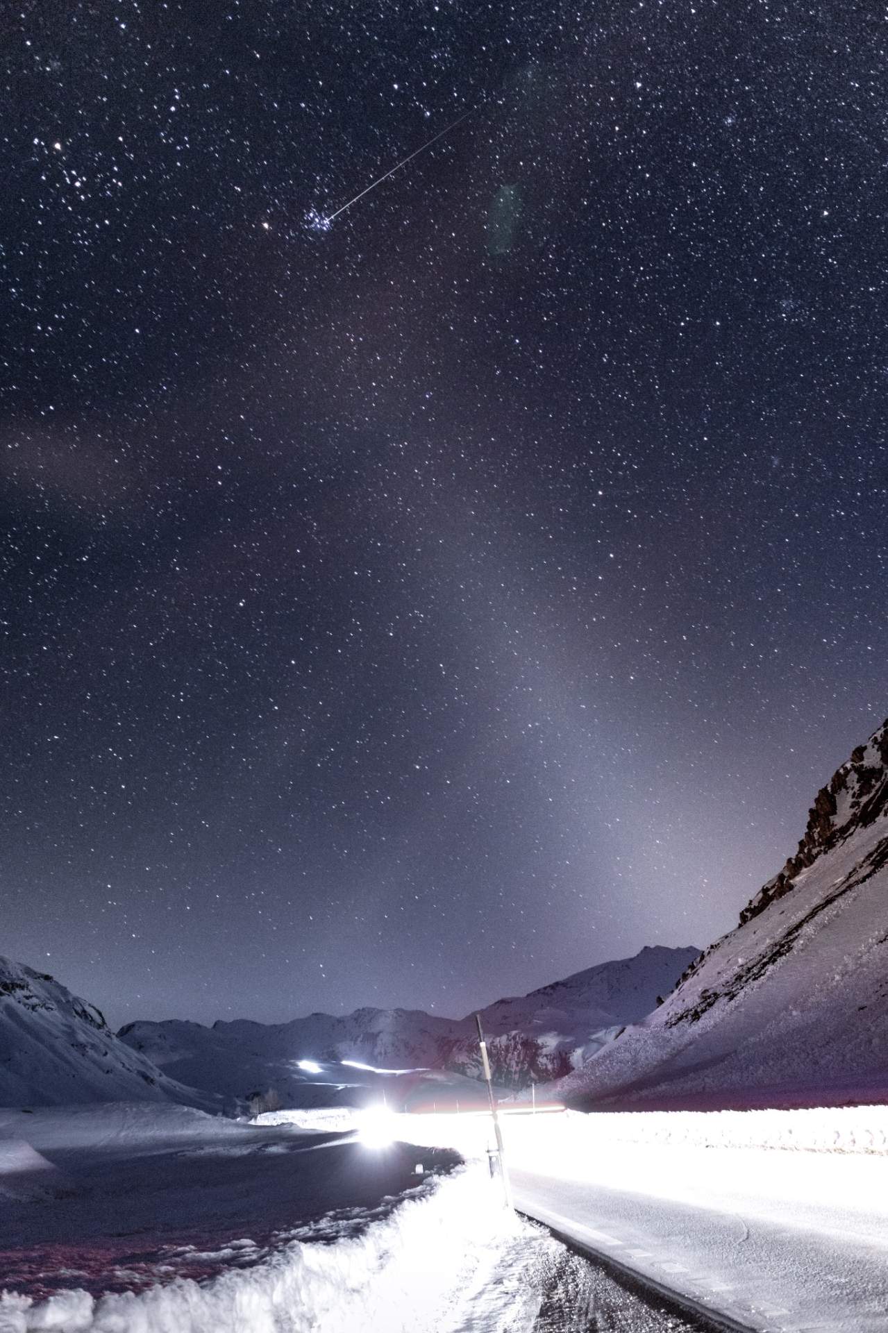 Abb. 1: Eine Sternschnuppe in einer eisigen Winternacht über dem Julierpass im Kanton Graubünden. Gut zu erkennen auch das ausgeprägte Zodiakallicht (Lichtkegel in der unteren rechten Bildhälfte). Fotografiert von Dominic Kurz von UwBe International im März 2021.